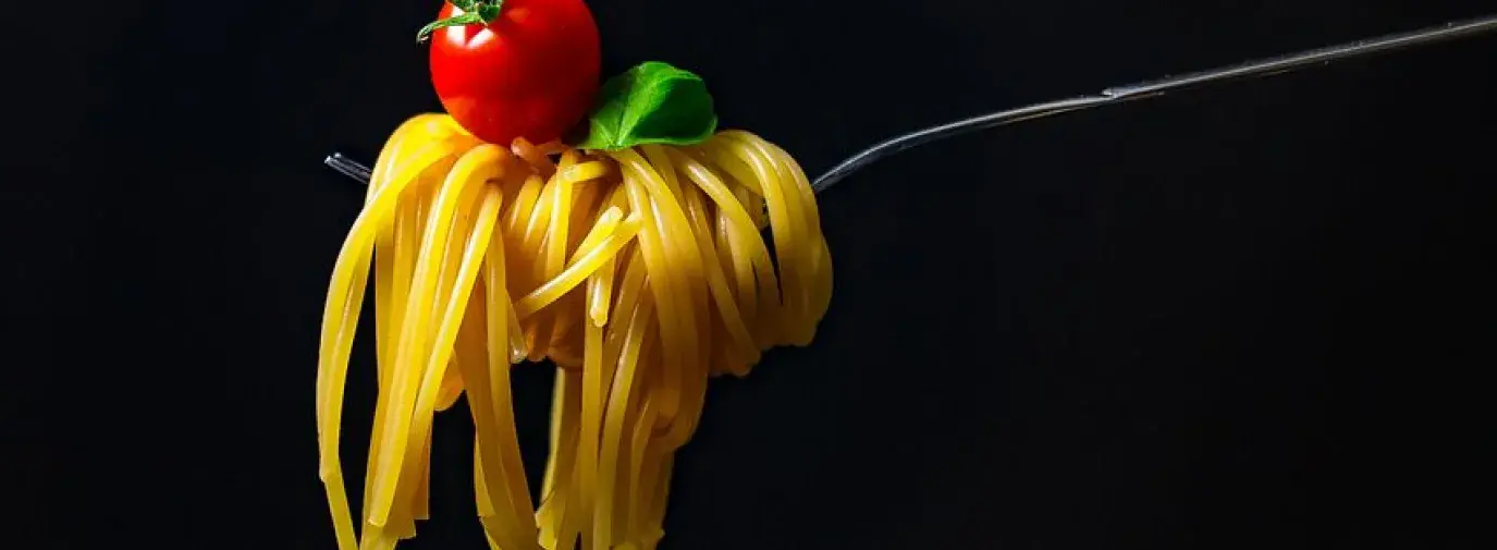 fork with pasta lettuce and tomato. 